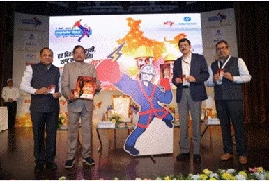 लाइनमैन दिवस के मंच पर पुस्तिका दिखाते अतिथि